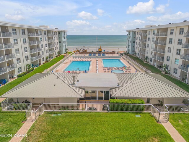 view of pool with a yard and a water view