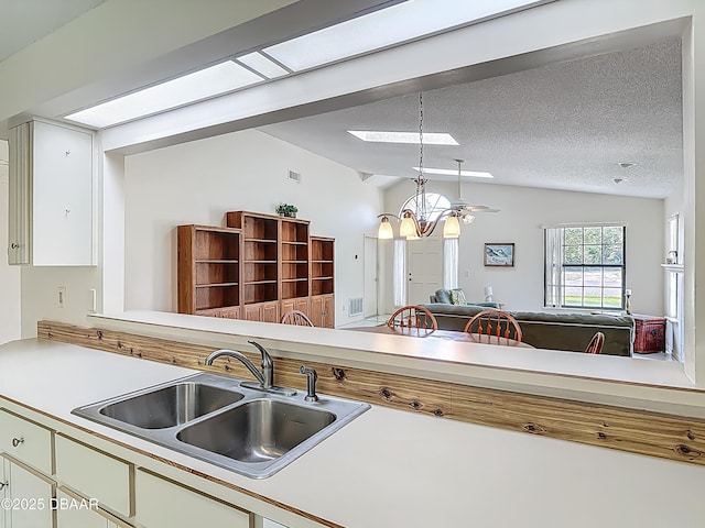 907 Silverleaf Pl, Port Orange, FL 32127 - kitchen featuring a sink, lofted ceiling, an inviting chandelier, open floor plan, and light countertops
