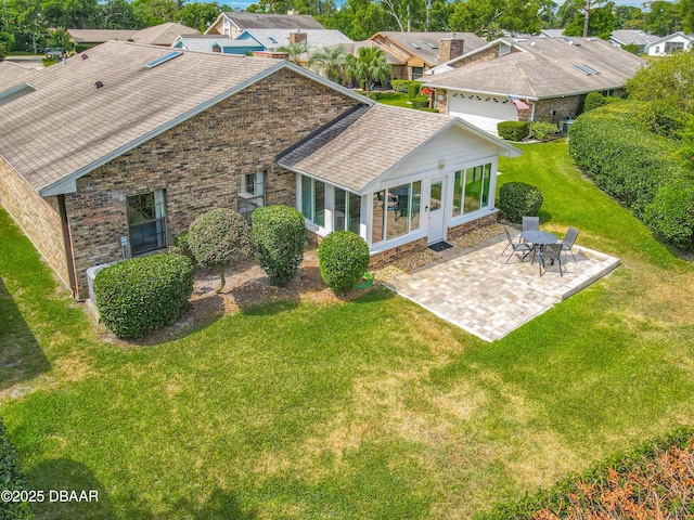 907 Silverleaf Pl, Port Orange, FL 32127 - rear view of house featuring a lawn, brick siding, a patio, a sunroom, and a shingled roof