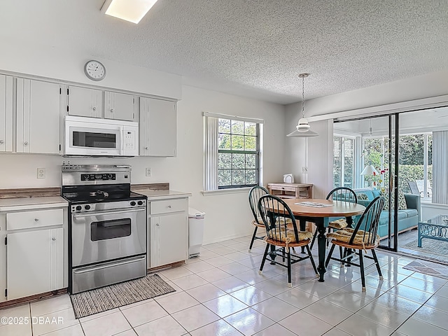 907 Silverleaf Pl, Port Orange, FL 32127 - kitchen featuring white microwave, a textured ceiling, stainless steel range with electric stovetop, and light countertops