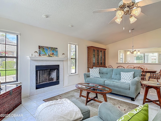 907 Silverleaf Pl, Port Orange, FL 32127 - living room featuring light tile patterned floors, a wealth of natural light, a fireplace, and ceiling fan with notable chandelier