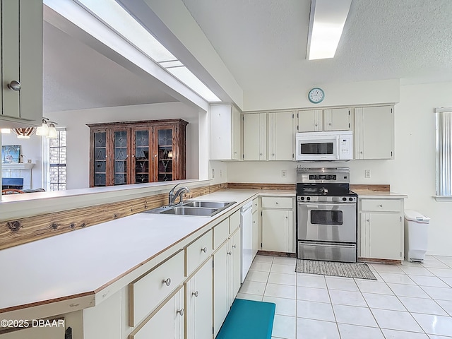 907 Silverleaf Pl, Port Orange, FL 32127 - kitchen with light tile patterned floors, a sink, white cabinets, white appliances, and light countertops