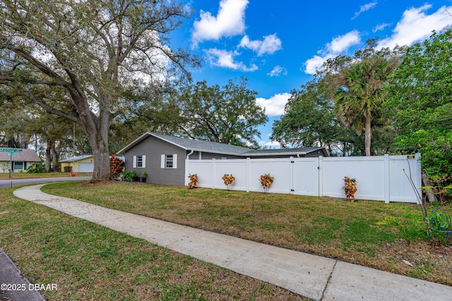 view of home's exterior with a yard, driveway, fence private yard, and a gate