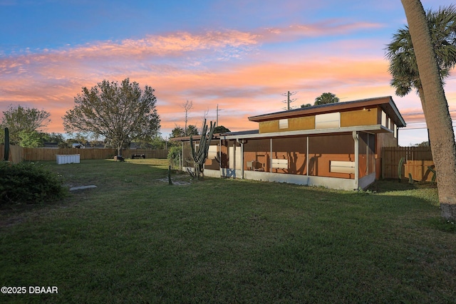 exterior space featuring a fenced backyard, a yard, and a sunroom