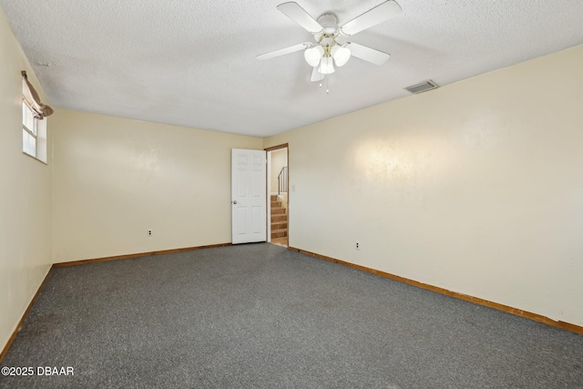 unfurnished room with visible vents, baseboards, a textured ceiling, and ceiling fan