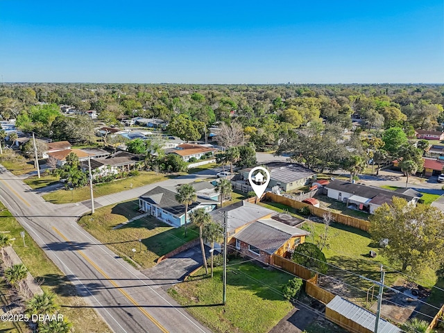 drone / aerial view featuring a residential view and a wooded view