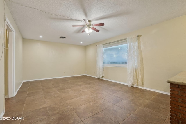 unfurnished room with a textured ceiling, visible vents, baseboards, and ceiling fan