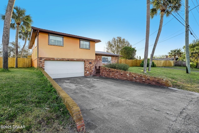 view of front of home with a front lawn, fence, aphalt driveway, stucco siding, and an attached garage