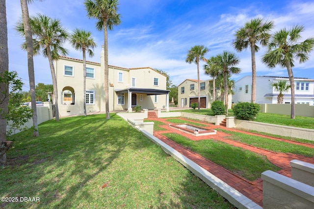 mediterranean / spanish home featuring a front yard and a garage