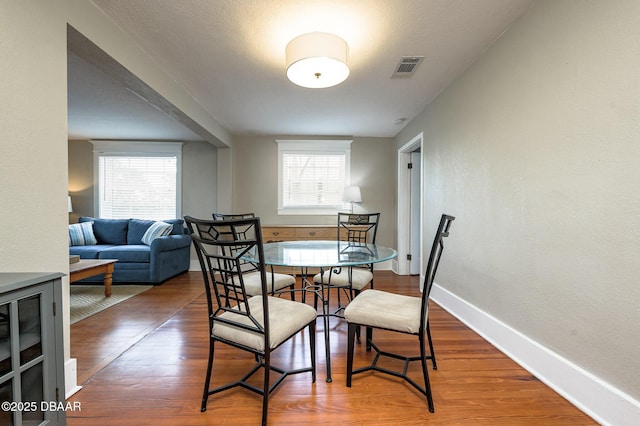 dining area featuring hardwood / wood-style flooring and a healthy amount of sunlight