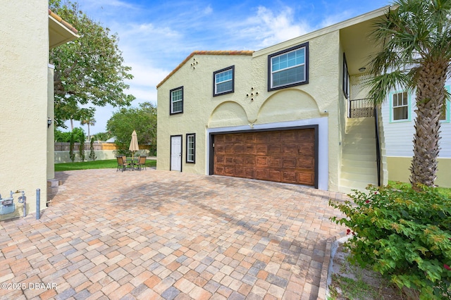 mediterranean / spanish-style home featuring a patio area and a garage