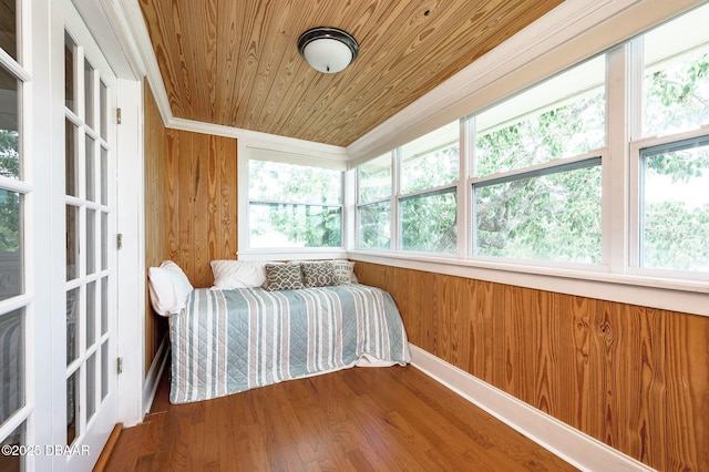 bedroom featuring wood ceiling, wooden walls, and wood-type flooring