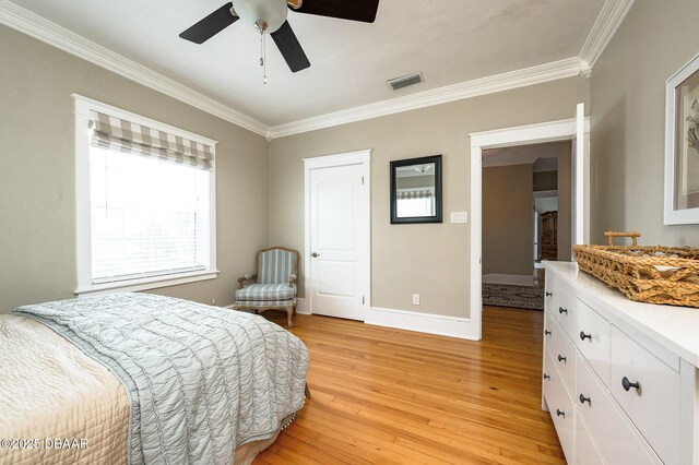 bedroom featuring ceiling fan, light wood-type flooring, and crown molding