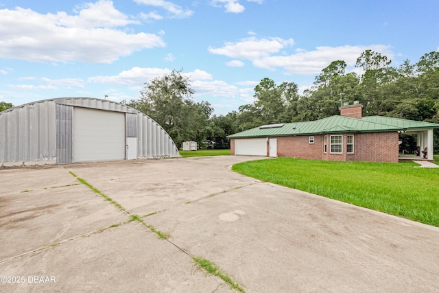 view of side of property with brick siding, a yard, a chimney, a standing seam roof, and metal roof