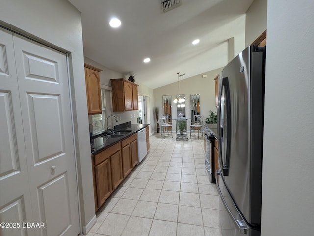 kitchen with visible vents, dark countertops, appliances with stainless steel finishes, brown cabinets, and decorative light fixtures