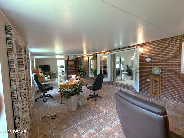 living room with a healthy amount of sunlight and brick wall