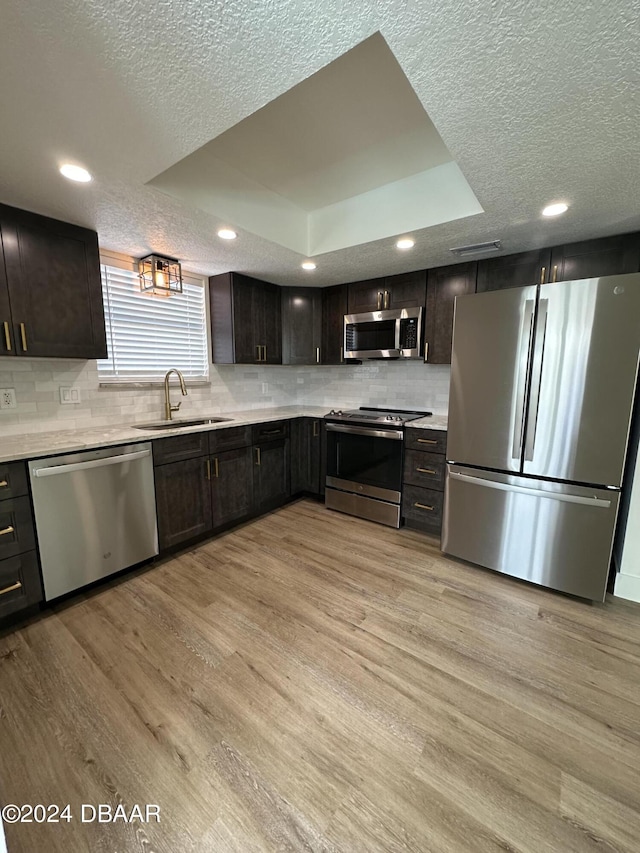 1824 Sabal Palm Dr, Edgewater, FL 32132 - kitchen with stainless steel appliances, a sink, a textured ceiling, backsplash, and light wood-style flooring