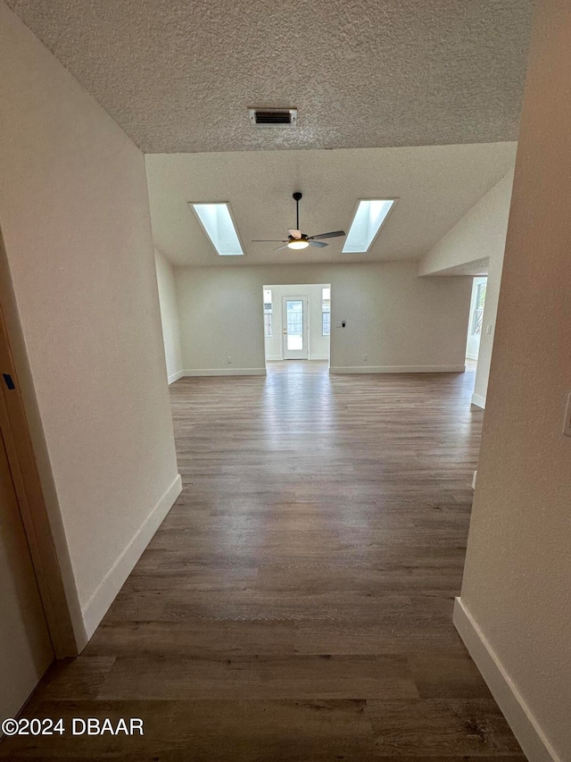 spare room featuring lofted ceiling, wood-type flooring, ceiling fan, and a textured ceiling