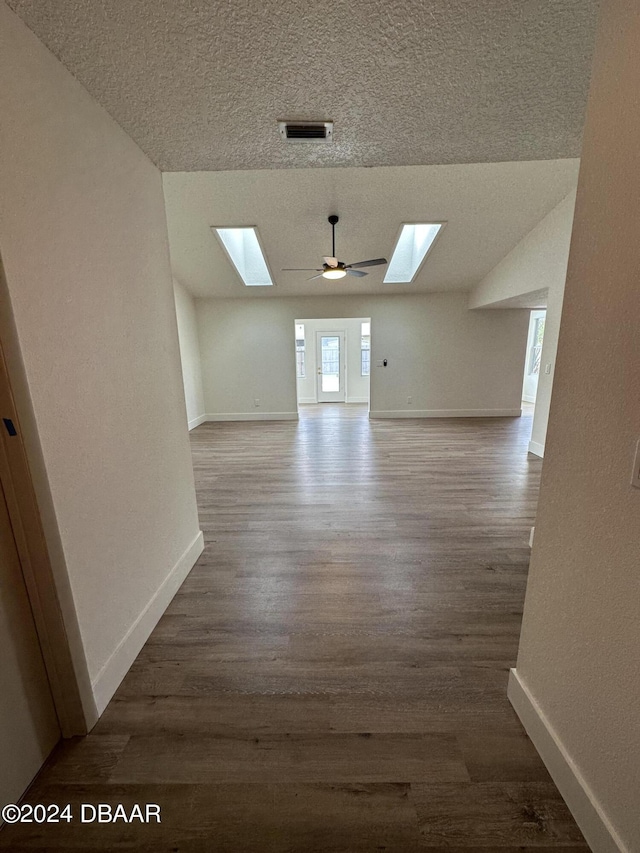1824 Sabal Palm Dr, Edgewater, FL 32132 - unfurnished room with a skylight, wood finished floors, a textured ceiling, baseboards, and lofted ceiling