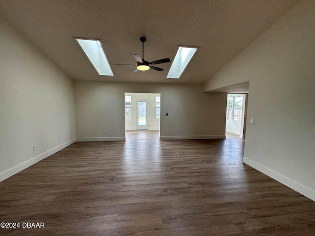 unfurnished living room with dark wood-type flooring, a wealth of natural light, and ceiling fan