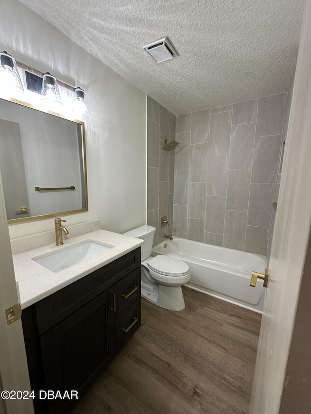 1824 Sabal Palm Dr, Edgewater, FL 32132 - bathroom featuring a textured ceiling, wood finished floors, vanity, toilet, and shower / washtub combination