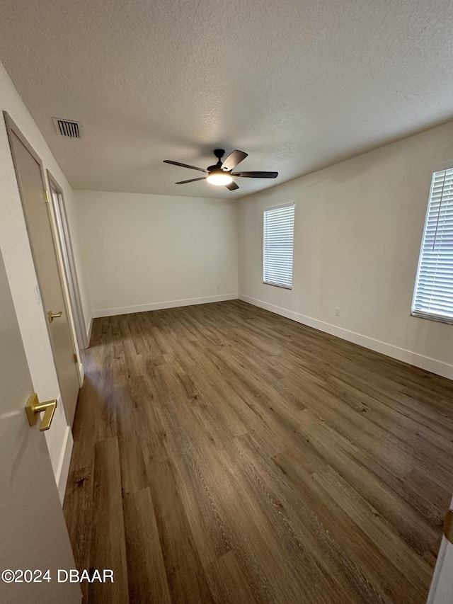 1824 Sabal Palm Dr, Edgewater, FL 32132 - spare room featuring a textured ceiling, dark wood finished floors, ceiling fan, and baseboards