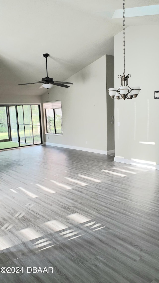 unfurnished living room featuring high vaulted ceiling, hardwood / wood-style flooring, and ceiling fan with notable chandelier