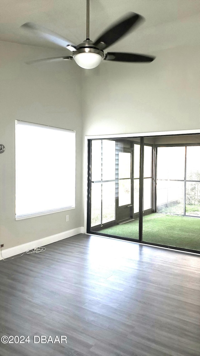 empty room featuring ceiling fan, hardwood / wood-style floors, and a healthy amount of sunlight