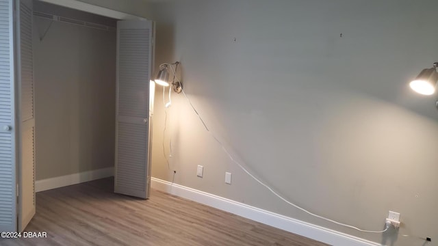 unfurnished bedroom with a closet and hardwood / wood-style floors