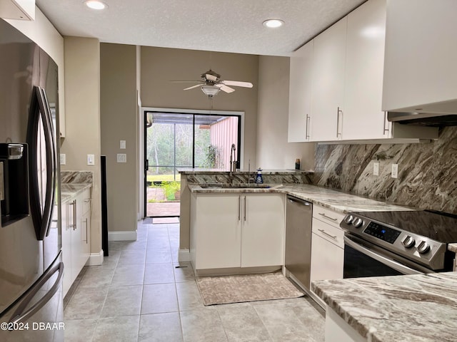 kitchen featuring white cabinets, appliances with stainless steel finishes, a textured ceiling, and light stone countertops