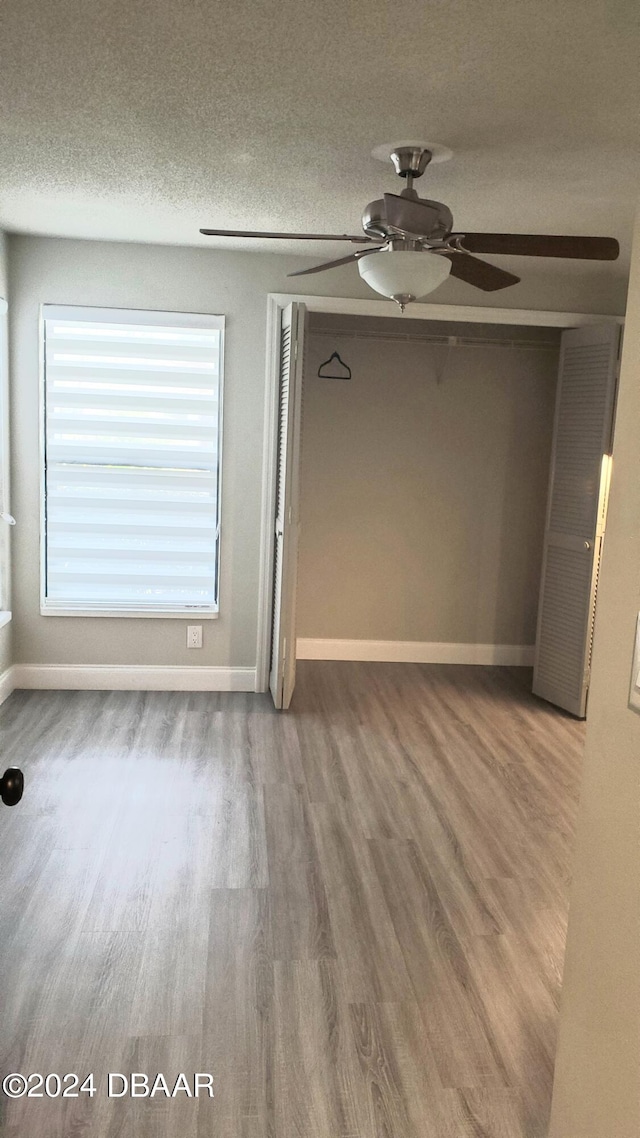 unfurnished room featuring wood-type flooring, ceiling fan, and a textured ceiling