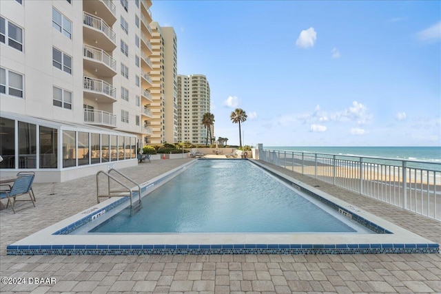 view of pool with a view of the beach and a water view