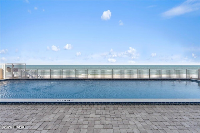 view of swimming pool featuring a water view