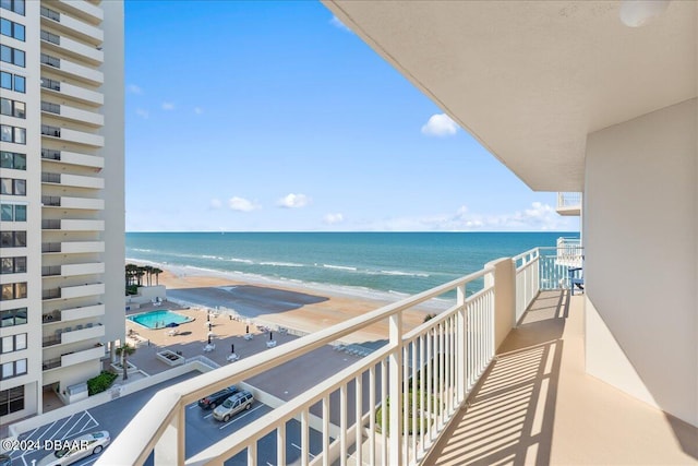 balcony featuring a beach view and a water view