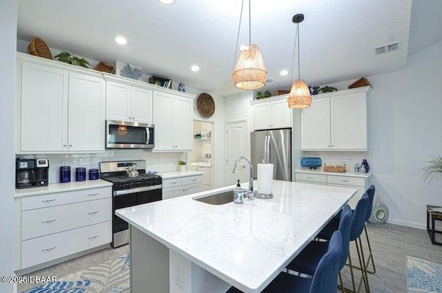 467 Salty Lime Pl, Daytona Beach, FL 32124 - kitchen with decorative backsplash, stainless steel appliances, a sink, visible vents, and a center island with sink