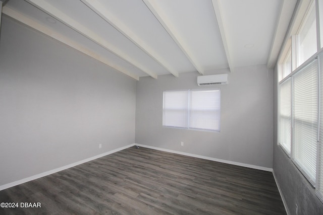 empty room with beam ceiling, a wealth of natural light, dark hardwood / wood-style flooring, and an AC wall unit