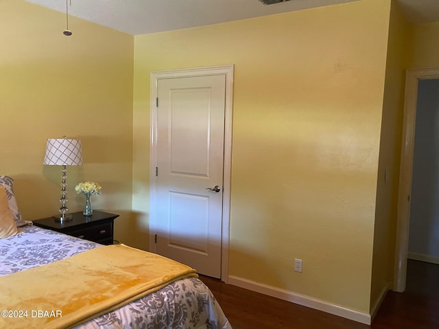 bedroom with dark hardwood / wood-style floors