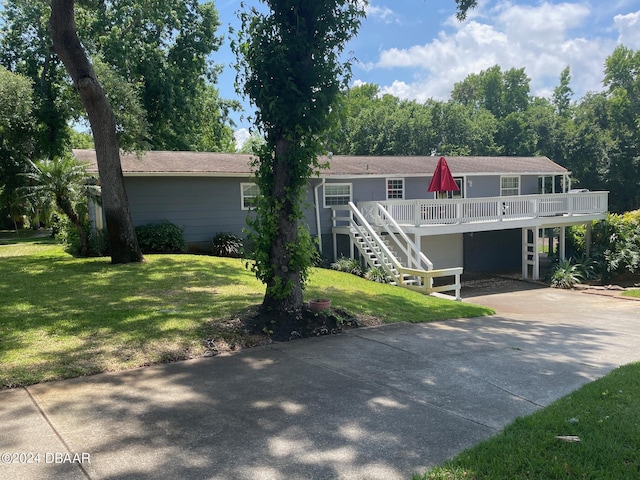 view of front facade featuring a front yard, a carport, and a deck