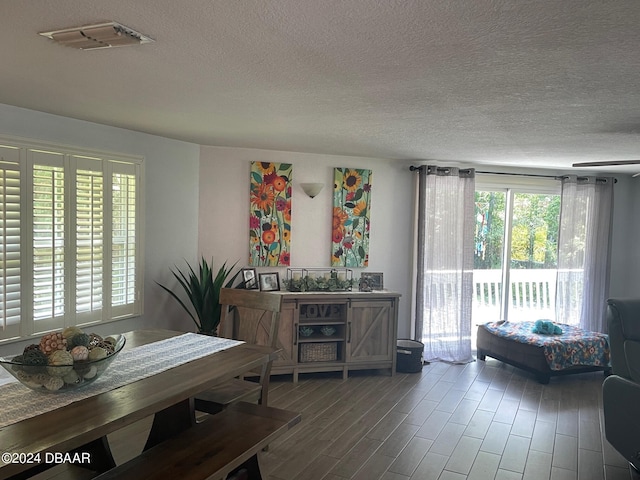 dining area with hardwood / wood-style floors and a textured ceiling