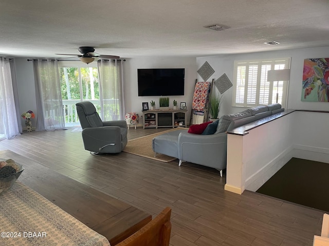 living room featuring a healthy amount of sunlight, ceiling fan, hardwood / wood-style flooring, and a textured ceiling