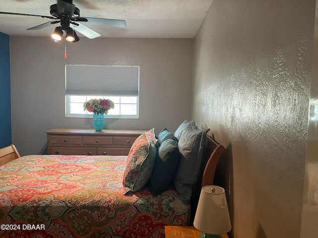 bedroom with ceiling fan and a textured ceiling