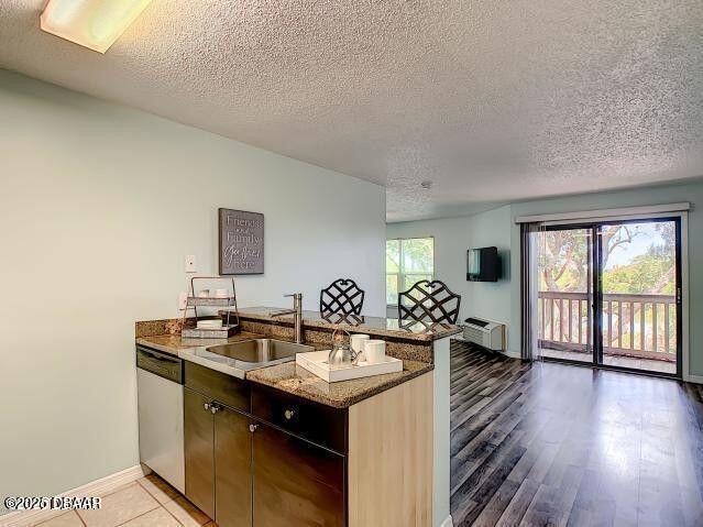 1401 S Palmetto Ave Unit 109, Daytona Beach, FL 32114 - kitchen featuring dishwasher, a peninsula, dark stone countertops, and a sink