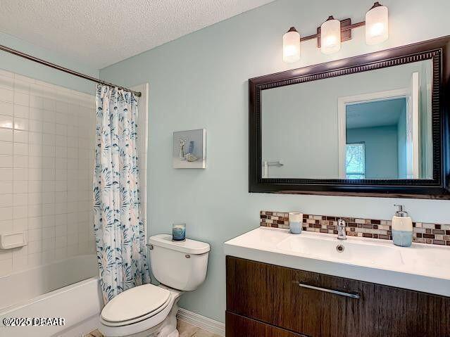 1401 S Palmetto Ave Unit 109, Daytona Beach, FL 32114 - bathroom with a textured ceiling, toilet, vanity, decorative backsplash, and shower / bath combination with curtain