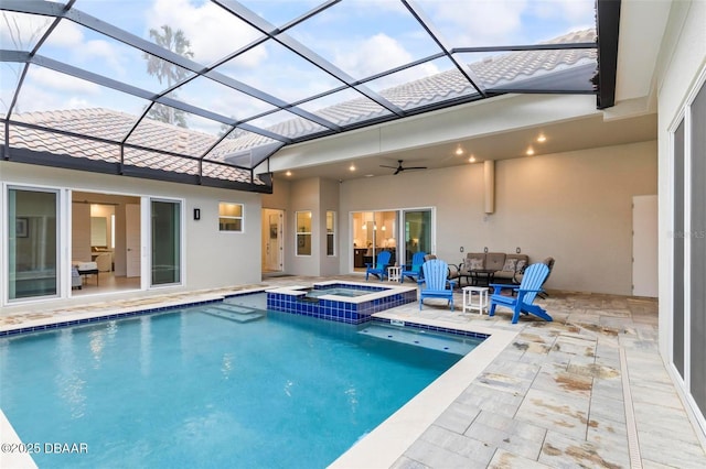 view of pool featuring glass enclosure, a patio, a ceiling fan, and a pool with connected hot tub