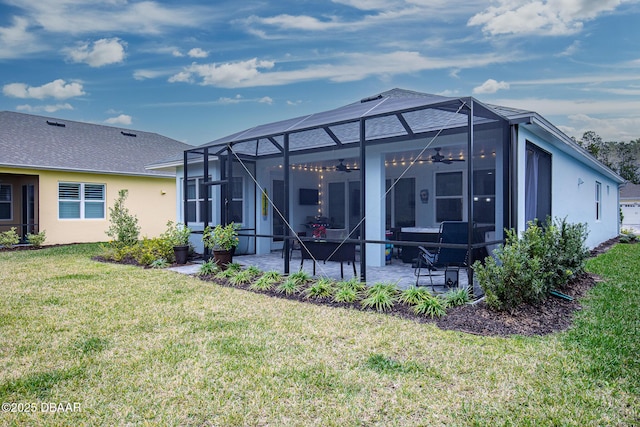 rear view of house with a lawn, a patio area, ceiling fan, and a lanai