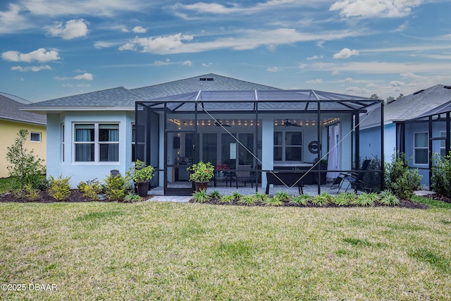 back of house featuring a lawn, a patio area, ceiling fan, and glass enclosure