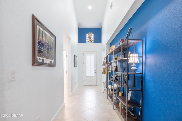 entryway featuring a towering ceiling and light tile patterned flooring