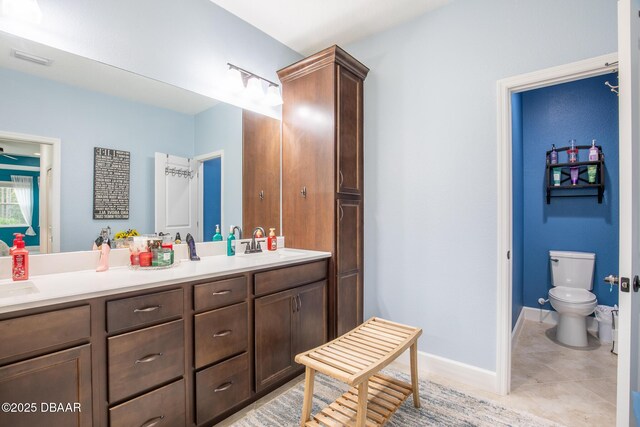 bathroom featuring toilet, vanity, and tile patterned flooring