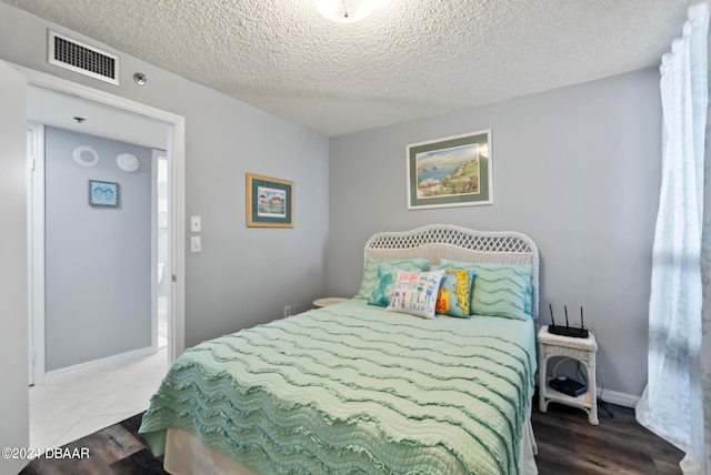 bedroom featuring a textured ceiling and hardwood / wood-style flooring