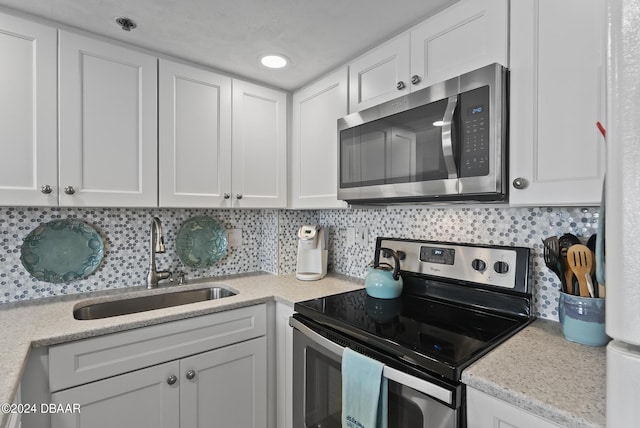 3023 S Atlantic Ave Unit 5020, Daytona Beach Shores, FL 32118 - kitchen featuring stainless steel appliances, a sink, white cabinetry, and decorative backsplash